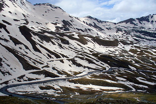  Patricius (vľavo dole v zákrute) zdoláva zmáčané stúpanie v polovici severnej rampy Col de la Bonette/Restefond.